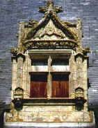 decorated attic window of birds, angels and foliage